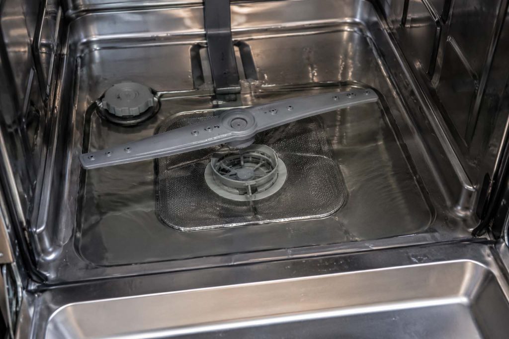 Standing water in the bottom of a stainless GE Monogram dishwasher tub